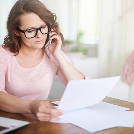 Kobieta czytająca niemiecką kartę podatkową Czym jest niemiecka karta lohnsteuerbescheinigung dzwoni do biura niemieckich rozliczeń podatkowych