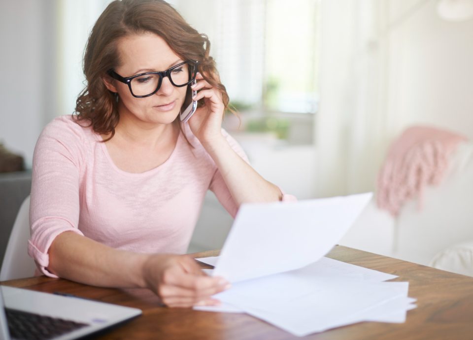 Kobieta czytająca niemiecką kartę podatkową Czym jest niemiecka karta lohnsteuerbescheinigung dzwoni do biura niemieckich rozliczeń podatkowych