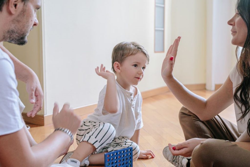 Rodzina spędzająca czas z dzieckiem w domowym zaciszu. Bezpieczeństwo finansowe i wsparcie dzięki uldze Kinderfreibetrag w Niemczech.
